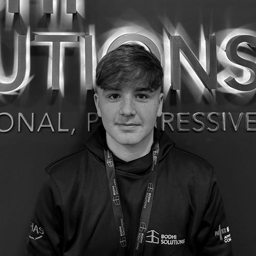 Young man wearing a Bodhi Solutions hoodie and lanyard stands in front of a wall with the company logo.