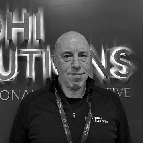 Man wearing Bodhi Solutions lanyard and jacket stands against a backdrop with the company logo.