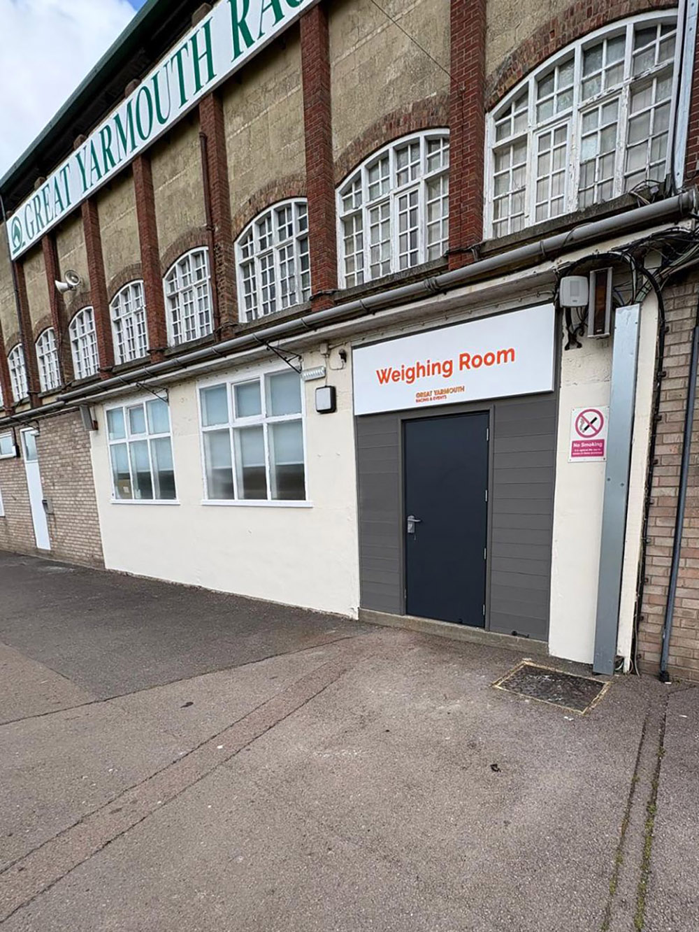 Exterior of Great Yarmouth Racecourse building with a door labeled Weighing Room.